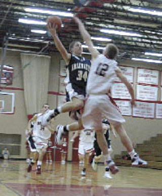Arlington guard Cole Carpenter goes up one-handed against Snohomish senior Brian Wolfe.