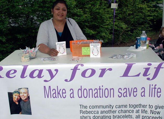 Arlington mother Rebecca Martinez shows off the multicolored cancer awareness bracelets that she donated to the Arlington Relay For Life