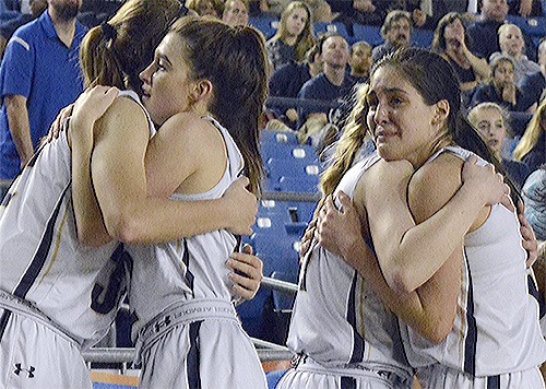 Arlington Eagle girls basketball team members hug and are in tears after losing the championship game to Bellevue March 5.