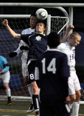 Arlington senior forward Jacob Fure competes for a header with a Kamiak defender in a Western Conference match April 6.
