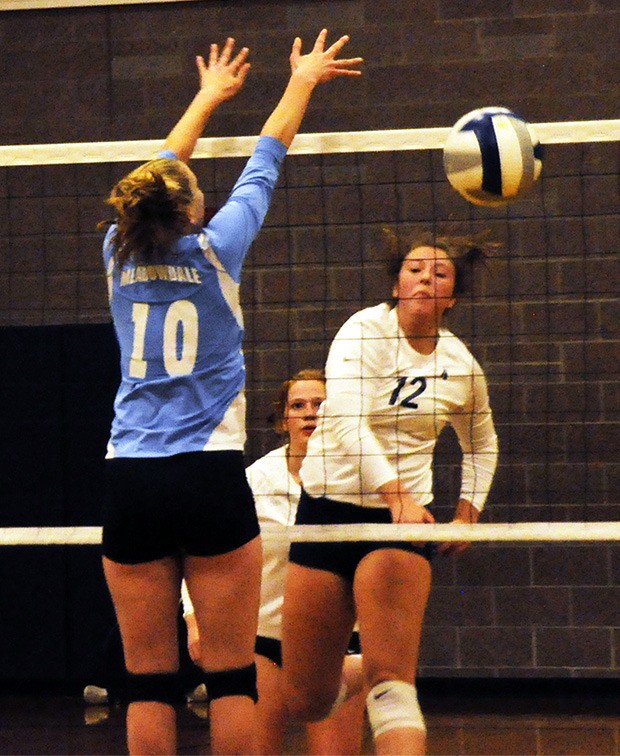 Rylie Rasor of Arlington spikes ball.