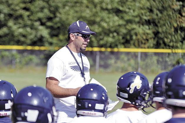 Head coach Greg Dailer speaks with varsity football players on the first day of practice