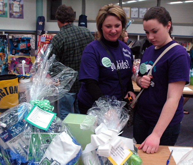 Kim and Grace Meno check out the silent auction at the Kent Prairie Elementary PTA Kiddie Carnival on March 22.