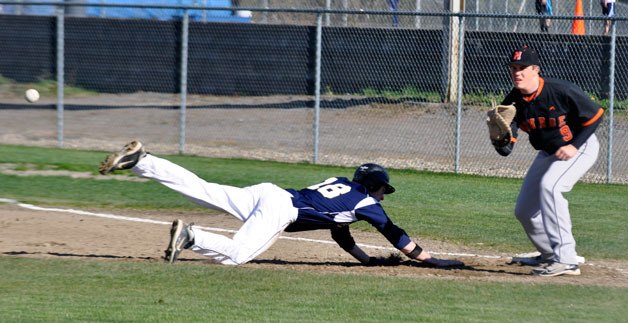 Arlington Eagles player DJ Smith slides back to first base during the April 13 home game against the Monroe Bearcats. Arlington won 9-1.