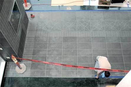 A construction worker applies tape to a stone walkway in Cascade Valley Hospital’s entryway Jan. 5.