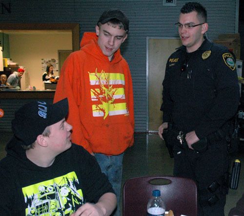 Arlington High School students Cody Boober and Michael Taylor interact with Arlington Police School Resource Officer Seth Kinney during lunchtime.