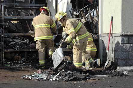 Crews sift through charred material at Smokey Point Plaza Tuesday