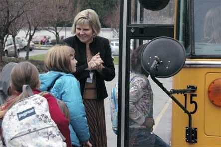 Eagle Creek principal Denise Putnam helps students get on the school bus on Feb. 11. The Arlington School Board projects that there will be an average of 5