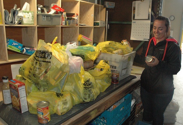 Arlington Community Food Bank volunteer Kortney Todd weighs 124 pounds of donated food during the May 10 Letter Carriersâ€™ Food Drive.
