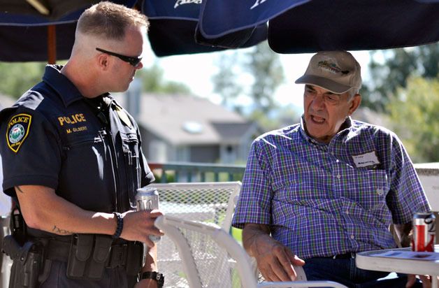 Officer Mike Gilbert of the Arlington Police Department speaks with Gleneagle resident Tony Macchiarella at the neighborhood’s National Night Out Against Crime on Tuesday