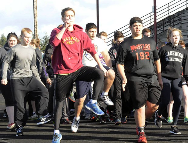 Lakewood's track and field team starts off its first practice of the season with warm up drills.