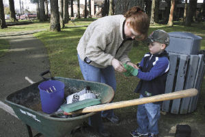 Arlington mom Gretchen Reed helps her son Cade don his work gloves.