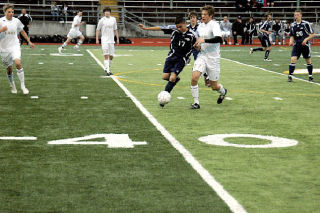 Junior midfielder Walter Flores challenges Lake Stevens forward Richard Franzmann for possession of the ball.