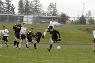 Senior Eric Hawks leaps and kicks powerfully defending the Lakewood goal. He kicks past Lynden forward Jesse Gonzalez to put Lynden on defense.