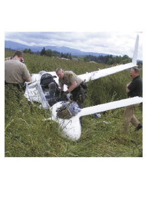 Deputies from the Snohomish County Sheriff’s Office check out the single-engine experimental aircraft which crashed in  a grassy field west of Arlington at approximately 10:50 a.m.