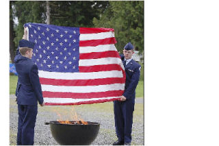 Members of the Air Force Junior ROTC of Arlington High School take part in retiring American flags at the Stillaguamish Valley Pioneer Museum June 14.