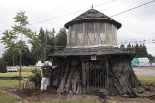 Stillaguamish Valley Pioneer Museum caretaker Marty Rausch is dwarfed