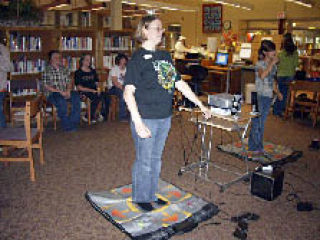 Jocelyn Redel tries to keep up with the teenagers dancing to Dance Dance Revolution at a new event for teens at the Arlington Library. Redel has been teen librarian since March. Redel earned her library degree in an on-line program through the University of Wisconsin in Milwaukee.