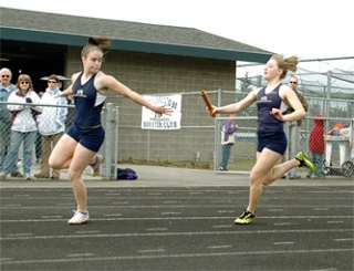 Arlington senior Shelby Townsend looks back for the handoff from freshman Sadie Hitsky in the girls 4x100 relay.