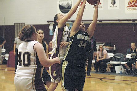 Sophomore post Ashlie Jensen tries to grab a rebound out of a Meridian player's hands.