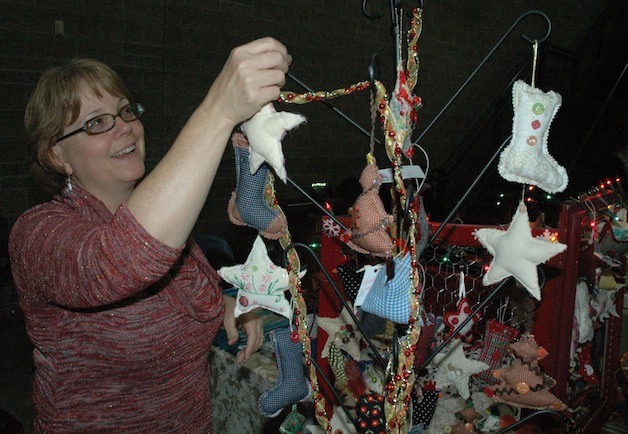 Tracy Borreson hangs handmade decorations for Matilda Jane Creations at the Arlington High School ‘Holiday Shoppe’ on Nov. 23.