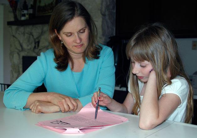 Stephanie Dickson helps 10-year-old daughter Elizabeth with her homework.