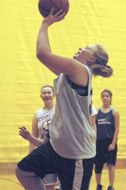 Sophomore Kaylee Diggs lays a ball in during a drill as teammates look on. Diggs is the Cougars sole returning starter.