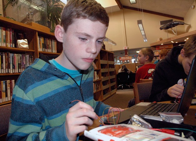 Isaac Davis studies the guide for assembling his circuit board during the fourth and final week of the ‘Explore Arduino’ course at the Arlington Library on Oct. 23.