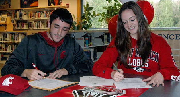Arlington High School seniors Ryan Walker and Morgan Ginnis sign letters of intent on Nov. 13.