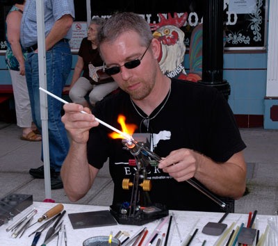 Marysville’s James Mills demonstrates how he makes his “Arcane Glass” artwork during the Arlington Street Fair on July 14.