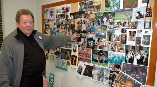 Father Jim Dalton studies his wall of memories at Immaculate Conception Church