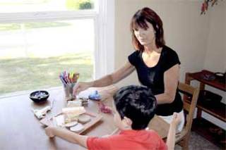 Stillwater School teacher Linda Henning supervises a student as he uses a glue-gun and pieces of wood to create art Sept. 11.