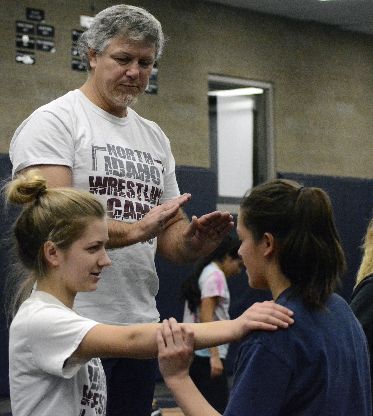 Arlington girls coach Jim Smoots instructs two wrestlers during a recent practice.                                Brandon Adam/Staff Photo