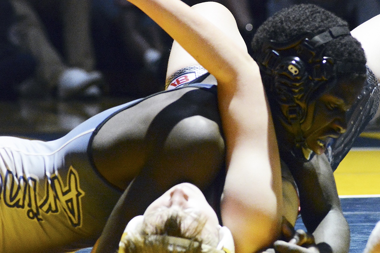 An Arlington wrestler works a pin.                                Brandon Adam/Staff Photo