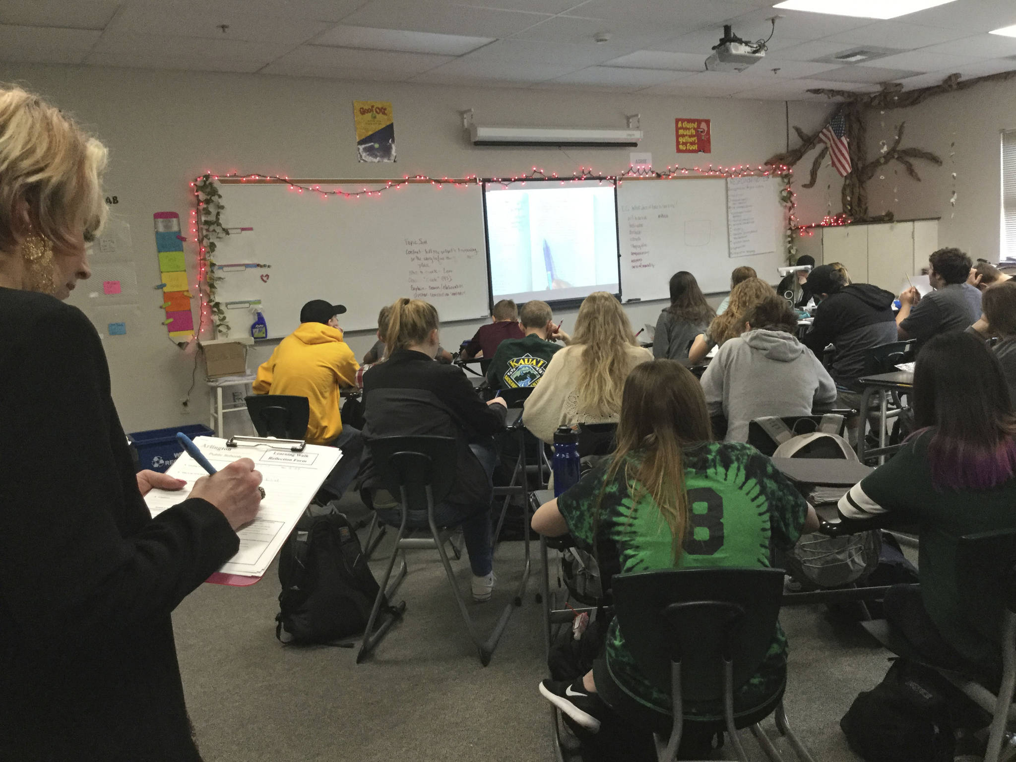 Parent Sheri Kelly jots down student and teacher observations in a Shakespeare-reading English class during a Learning Walk at Arlington High School. (Douglas Buell/Staff Photo)