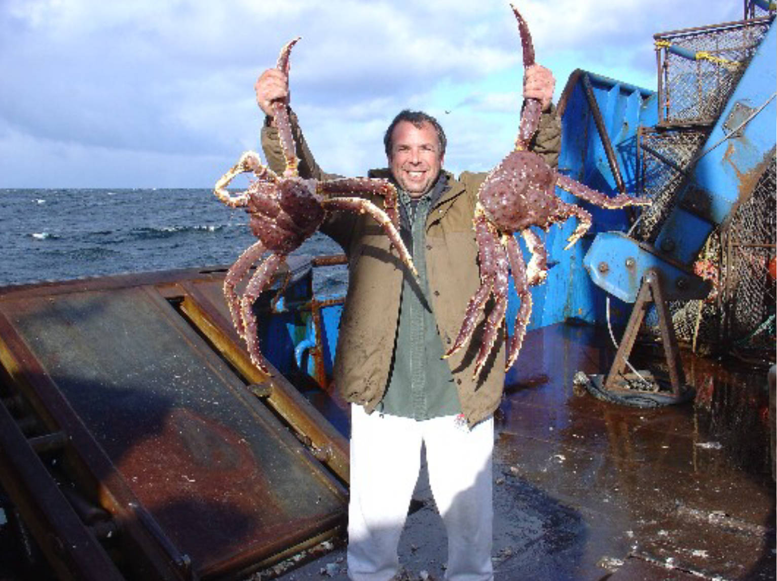 Dungeness Gear Works Presidence Lance Nylander hoists two Alaskan blue king crabs.