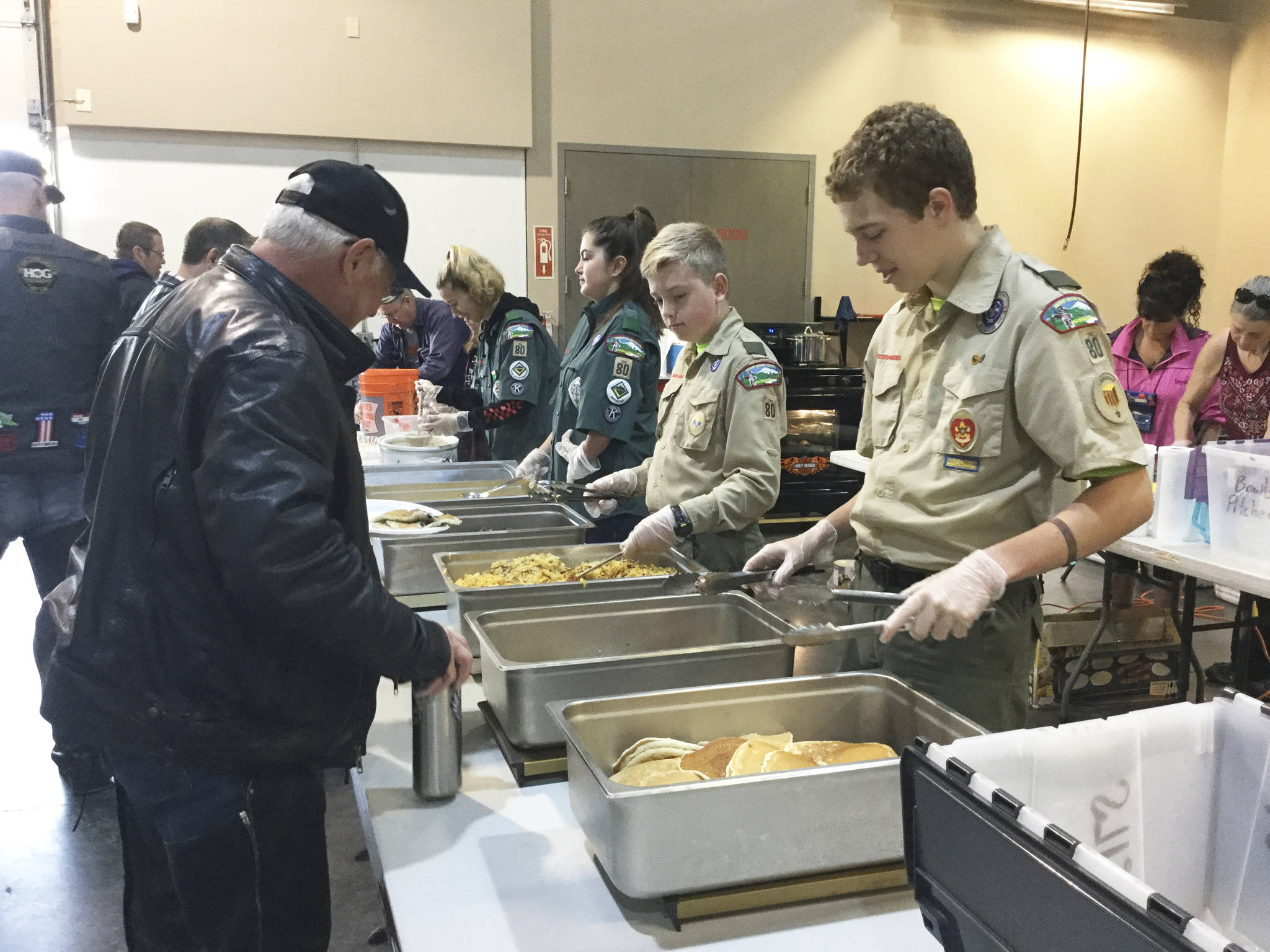 Marysville Troop 80 Boys Scouts and Ventures teens staff serve breakfast to hungry motorcycle riders at Sound Harley-Davidson on their way to the annual Oyster Run in Anacortes. Members of the hosting Marysville Kiwanis Club work behind the scenes cooking and preparing the breakfast and beverages.