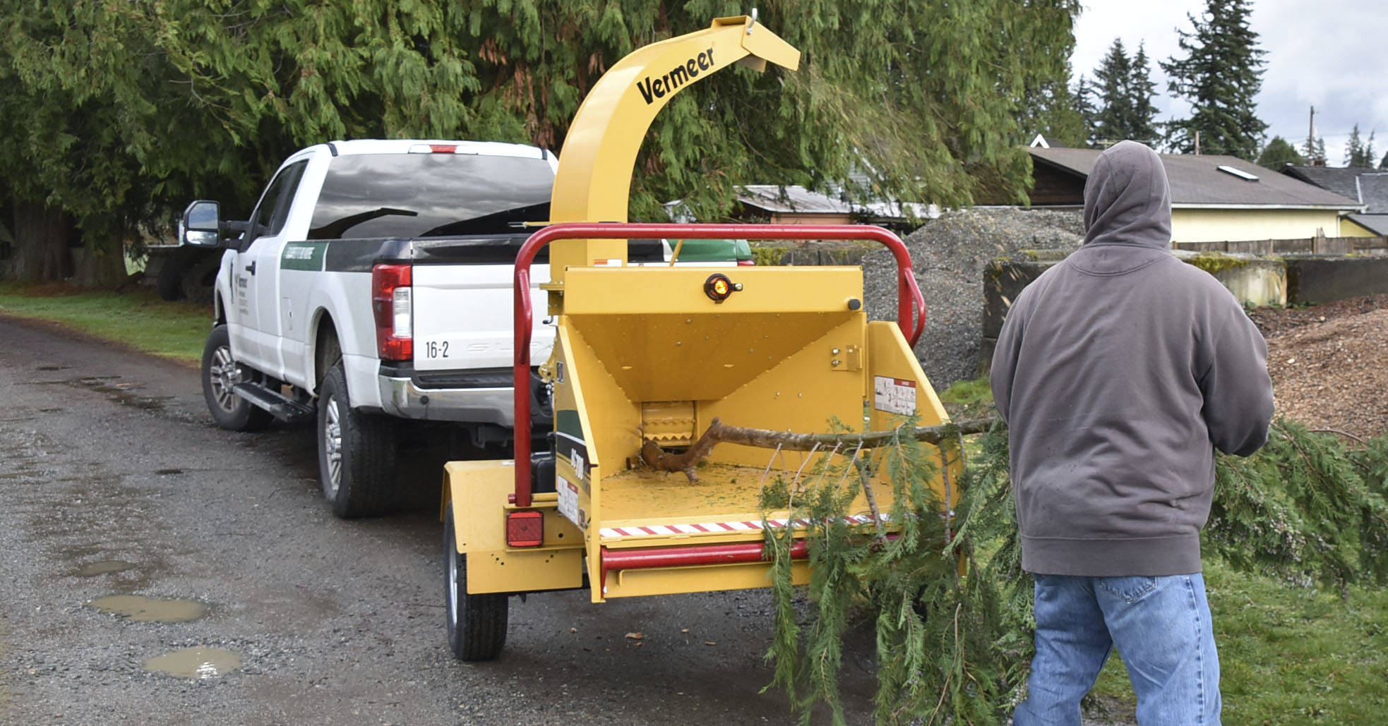 An Arlington Schools maintenance worker feeds a large branch through a chipper. Arlington Public Schools recently received a Healthy Kids-Healthy Schools grant to buy the chipper.