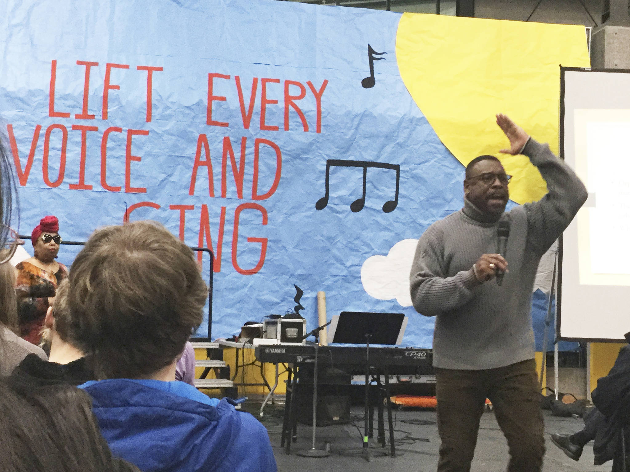 Stephen Newby talks about the influence of gospel music in Martin Luther King Jr.’s life; seated in background is Seattle gospel singer Joy Jones.