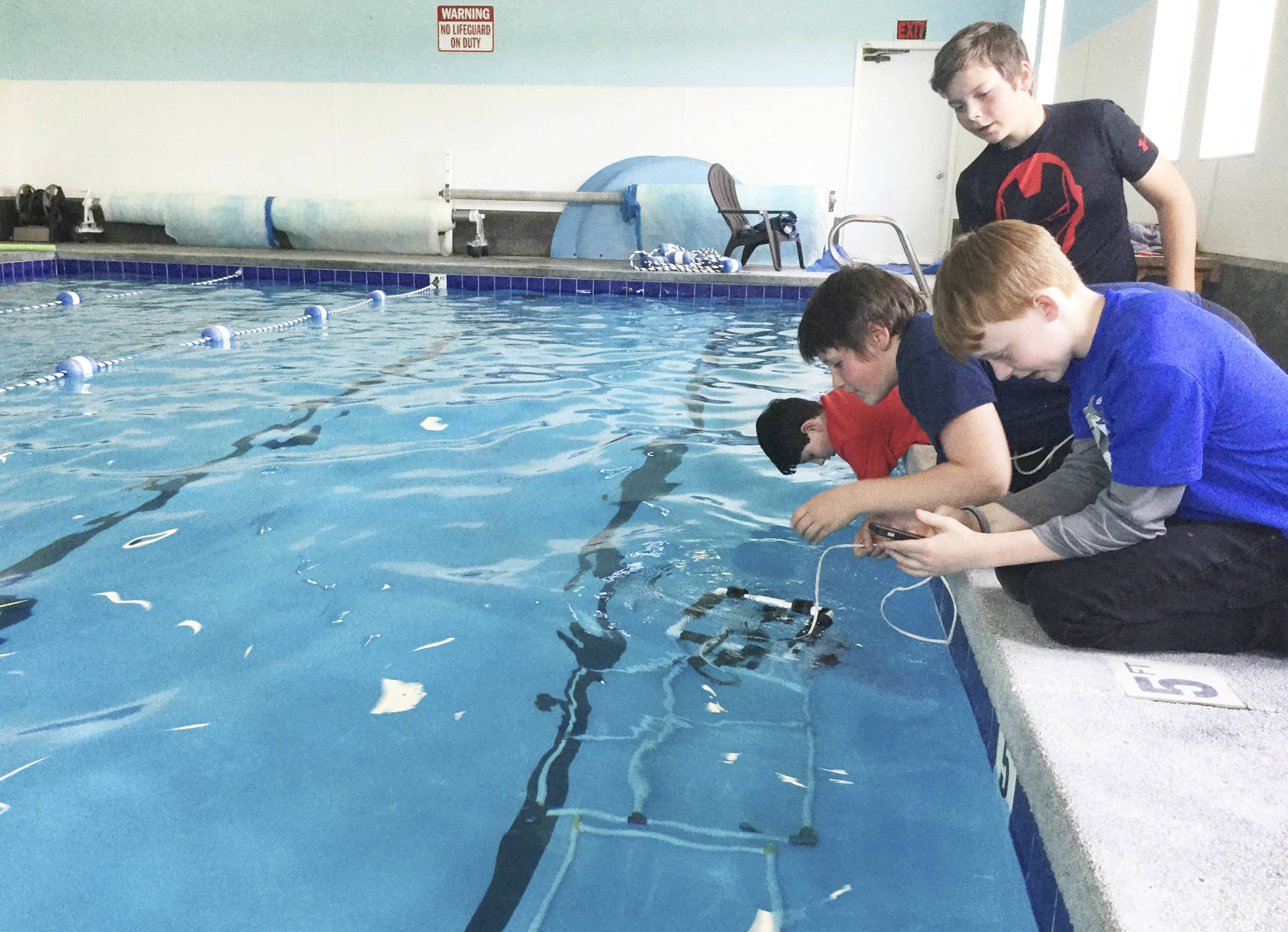 Arlington’s Haller Middle School sixth-graders test their remotely-operated vehicle (ROV) at the Stillaguamish Athletic Center in Arlington in advance of an underwater robotics competition Saturday in Federal Way. Their team, “Shoot The Rapids,” will simulate repairing cracks in a dam, among other challenges. From front, Gavin Dill, Cameron Bates, team captain Josiah Christoffersen and Simon Daley. Not pictured, Jacob Madriaga.