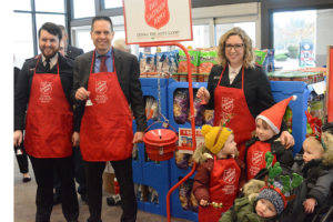 Lt. Ruari Ward, left, with Mayor Jon Nehring and Ward’s wife, Sarah, and their children, shown here at the Salvation Army bell ringing red kettle fund-raising drive before Christmas. (File Photo)