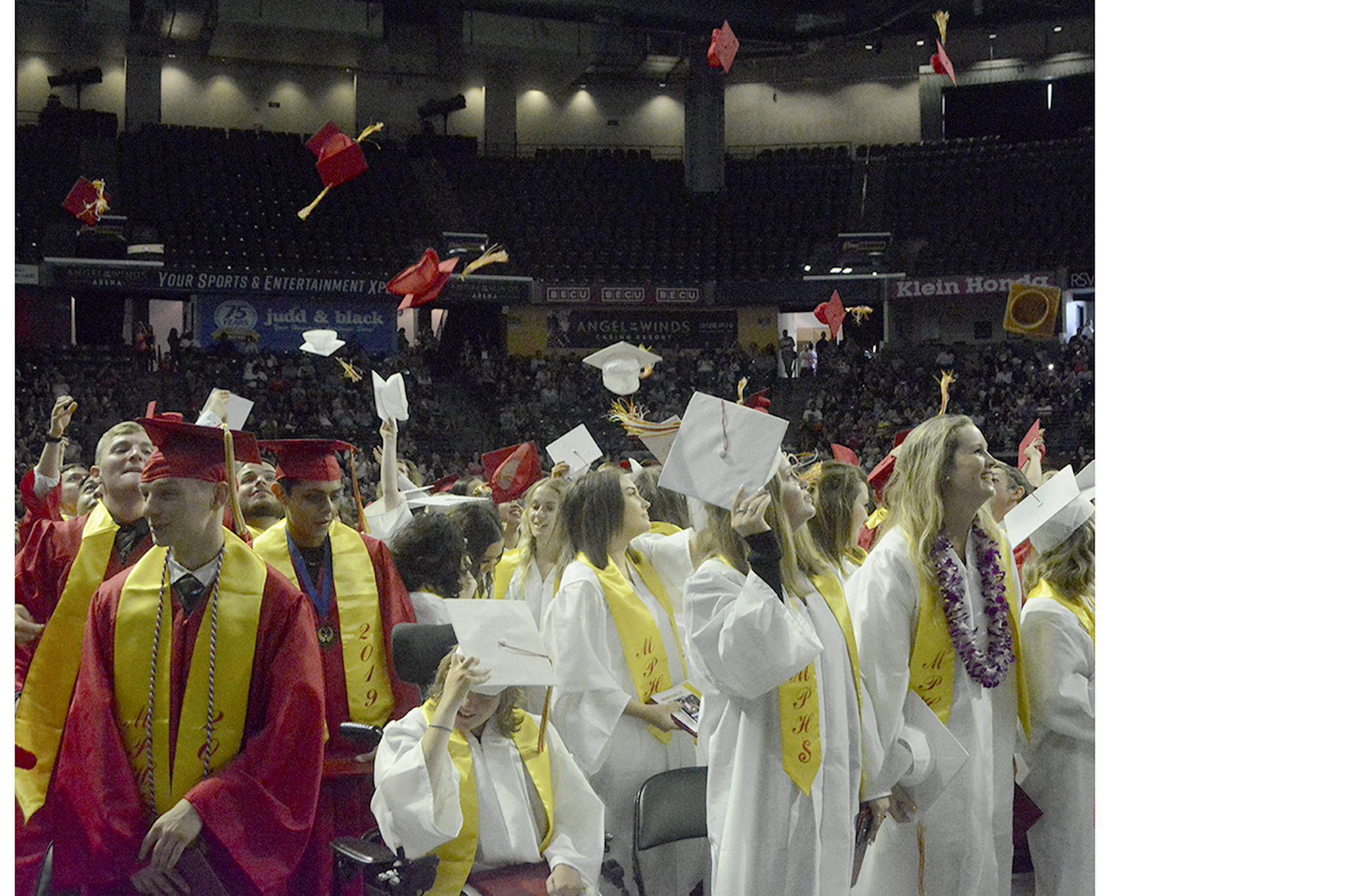 Some M-P graduates throw their caps into the air to celebrate at the end of the ceremony Wednesday.