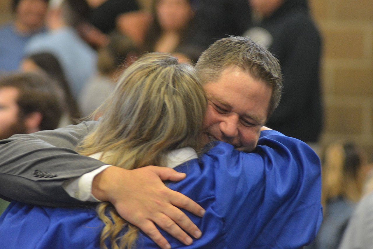 Teacher Trace Prael gets a big hug from a Mountain View Arts and Tech graduate. (Steve Powell/Staff Photos)