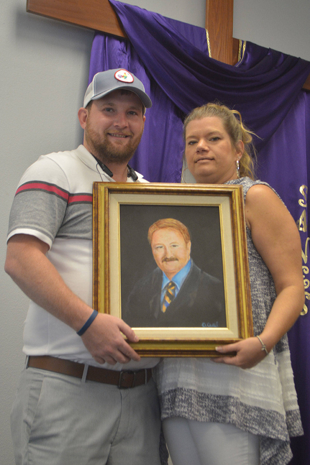 Steve Powell/Staff Photo                                 Jared and Lorrie Row hold a painting of Monte Row.