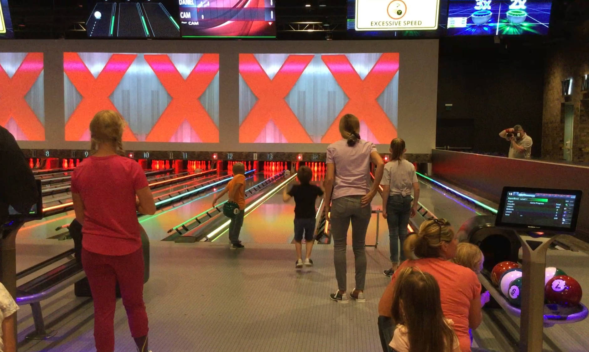 DOUGLAS BUELL/STAFF Photo                                 Kallen Boser, 4, hops up and down excitedly after knocking down the pins at Strikerz bowling alley at Angel of the Winds Casino Wednesday, while 6-year-old Camden Peterson and his sister, Danielle, 12, get ready to bowl.