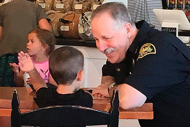 Retiring Police Chief Rick Smith talks to a youth. One of his goals was to make the department more approachable. (File Photo)