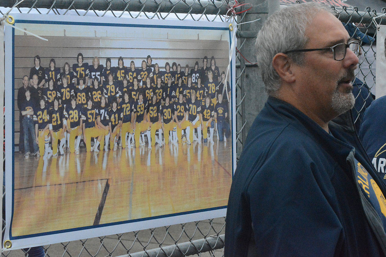Rich Senff stands next to a poster of the 1979 Arlington Eagles football team that won the state championship 40 years ago. (Steve Powell/Staff Photos)
