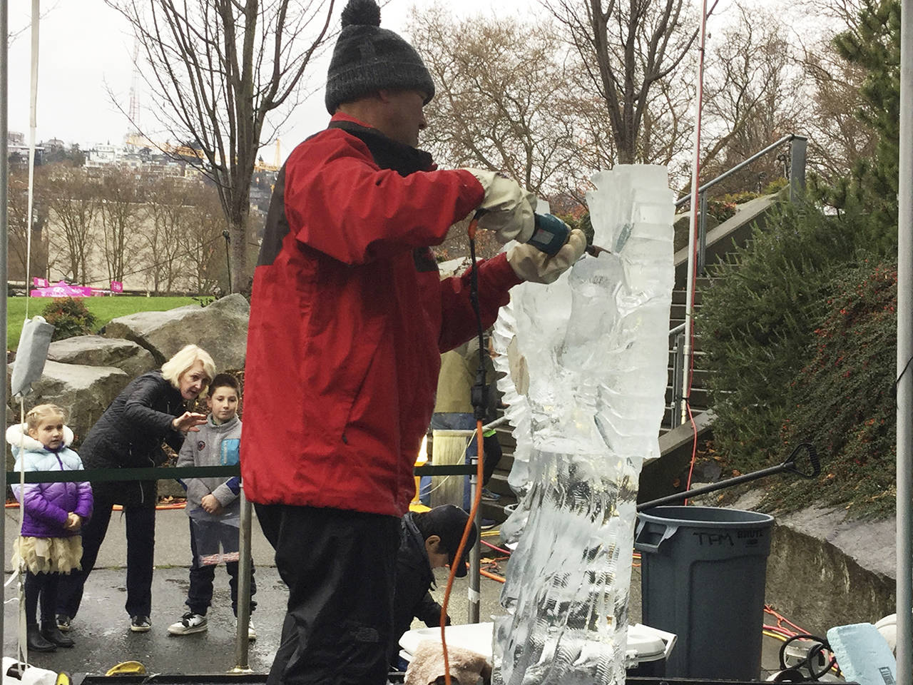 Kitburi uses a die grinder to smoothen the wings on an ice angel carving.