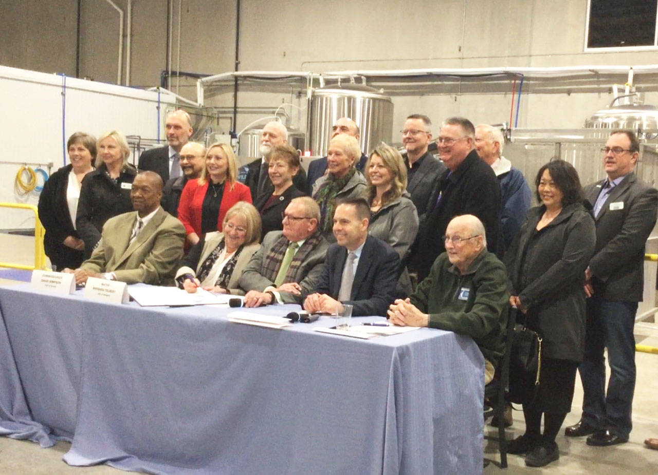 DOUGLAS BUELL/Staff Photo                                Arlington Mayor Barb Tolbert signs a memorandum of understanding to partner with Marysville and the Port of Everett to foster a booming Cascade Industrial Center manufacturing and industrial employment hub. The event was hosted at Elemental Cider Co. in Arlington, one of the newest businesses within the 4000-acre CIC area near the municipal airport. Seated from left, Port Commissioner David Simpson, Tolbert, Commissioner Glen Bachmann, Marysville Mayor Jon Nehring and Commissioner Tom Stiger.