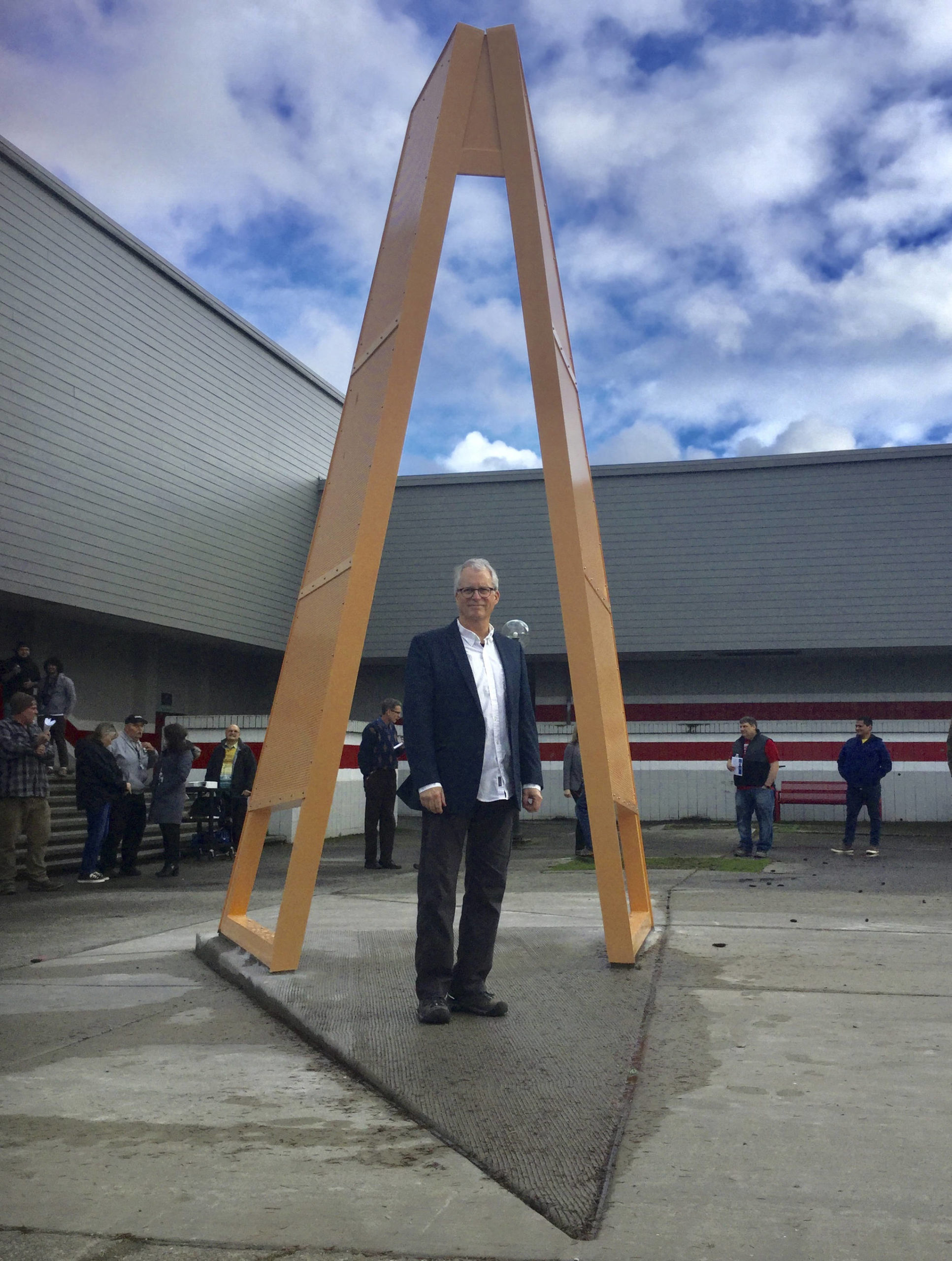 Artist Roger Feldman, professor emeritus at Seattle Pacific University, passes through his newest sculpture, “HopeGate” unveiled Friday at a ceremony outside Marysville-Pilchuck High School. The interactive sculpture combines Salish Sea Native American elements with a design that invites teens to pass through heading due west and “lean into the future.”
